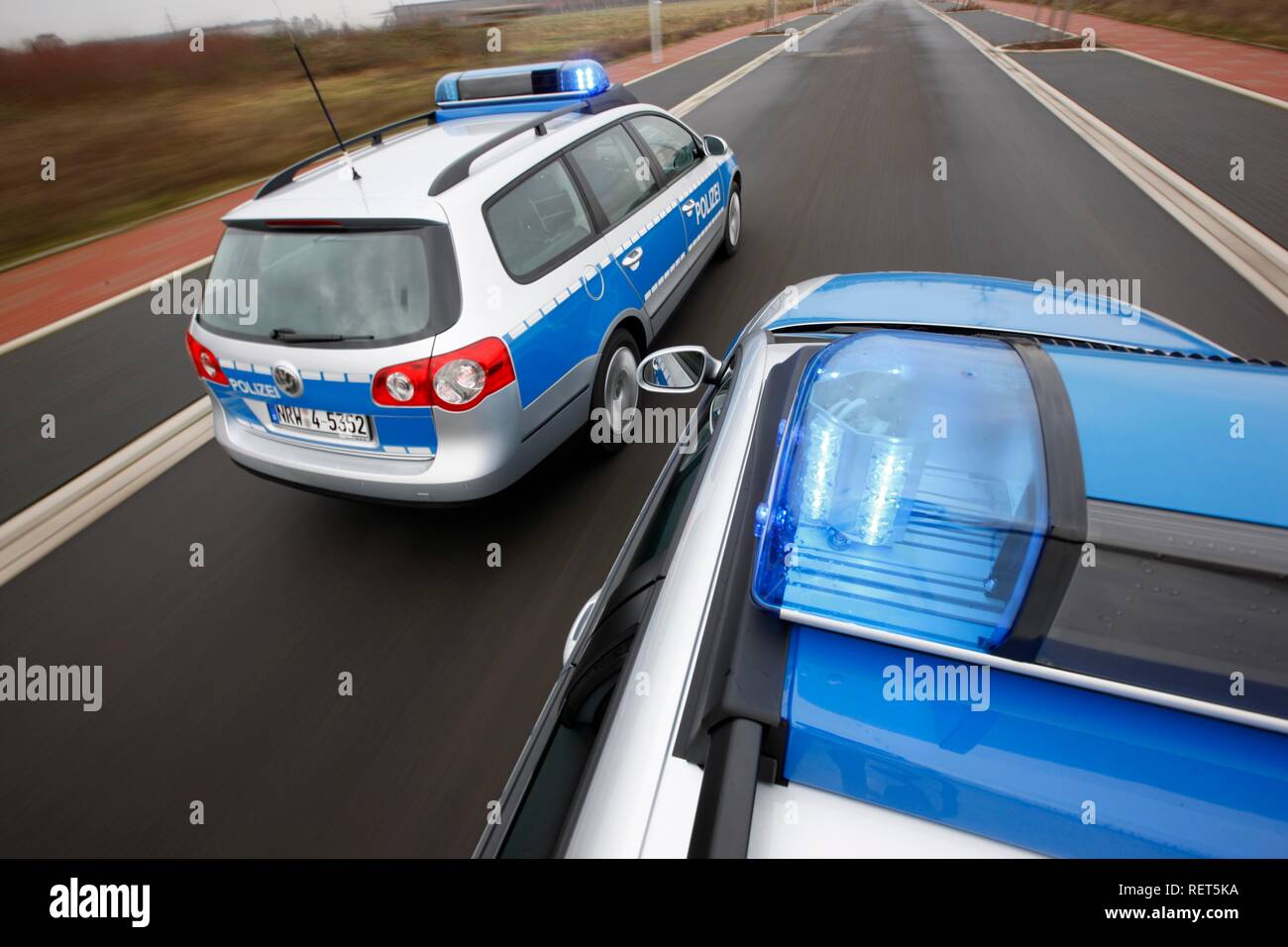 German police cars, blue design, in action with flashing sirens Stock Photo
