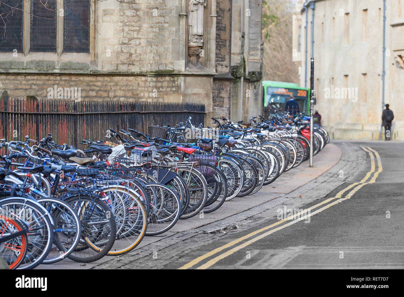 Bicycles parked  in an orderly line on Magdalen Street East outside the church of St Mary Magdalen and opposite an exterior wall of Balliol college. Stock Photo