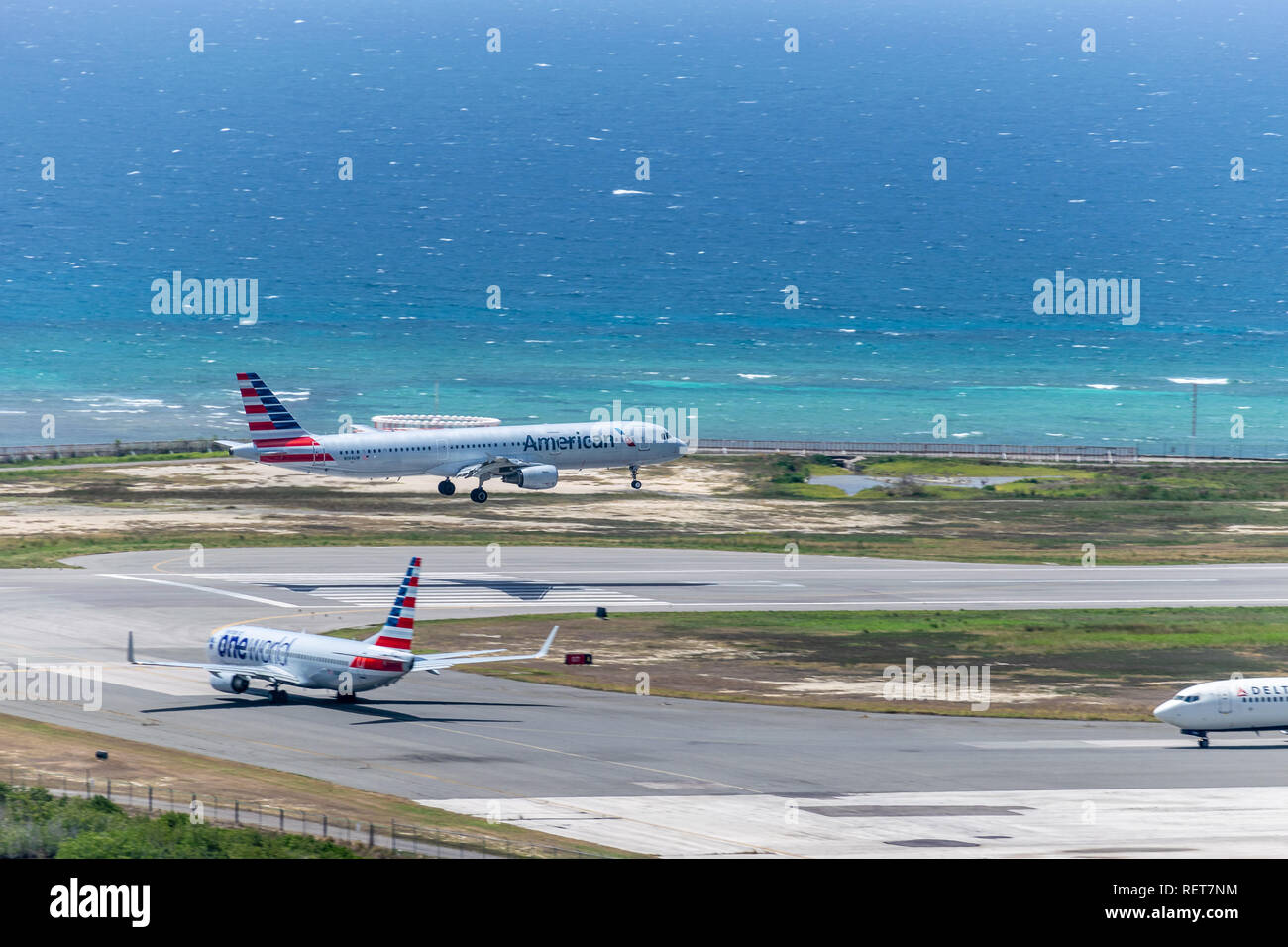 Montego Bay, Jamaica - July 03 2015: American Airlines aircraft landing and another waits to depart with Delta next in line, at Sangster International Stock Photo