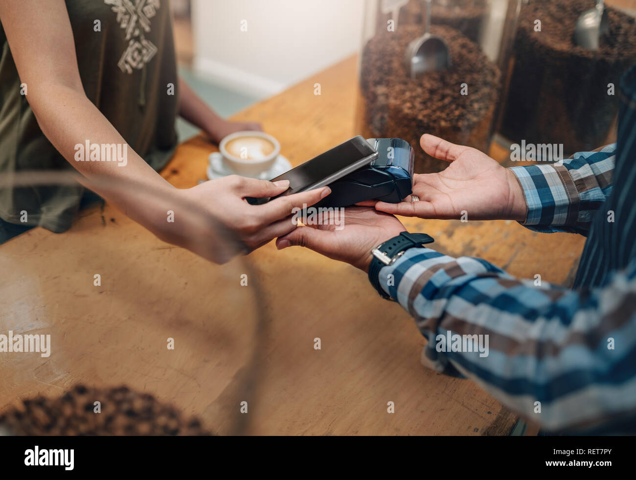 Customer making wireless or contactless payment using credit card using NFC technology. focus on hands Stock Photo
