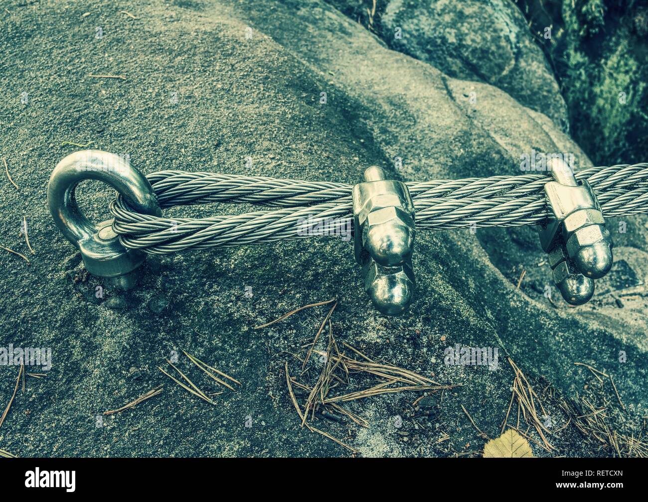 Mountain iron anchor for free climbing. Stainless cable fixed to the rock for the safety of the