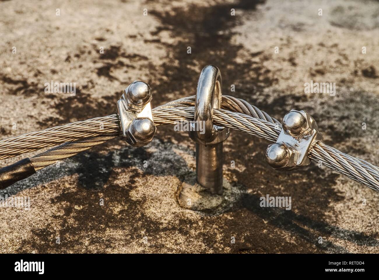 Climbing anchor or carabiner attached to the cliff rock. Difficult path