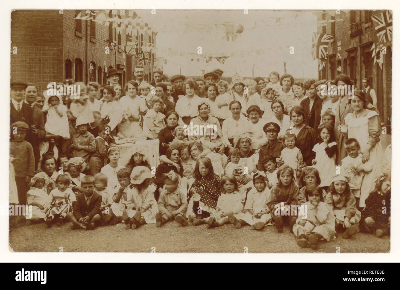 Postcard WW1 street peace party, fancy dress bonnets, Welcome home flag, Union Jacks, from Birmingham, U.K. 1918 Stock Photo