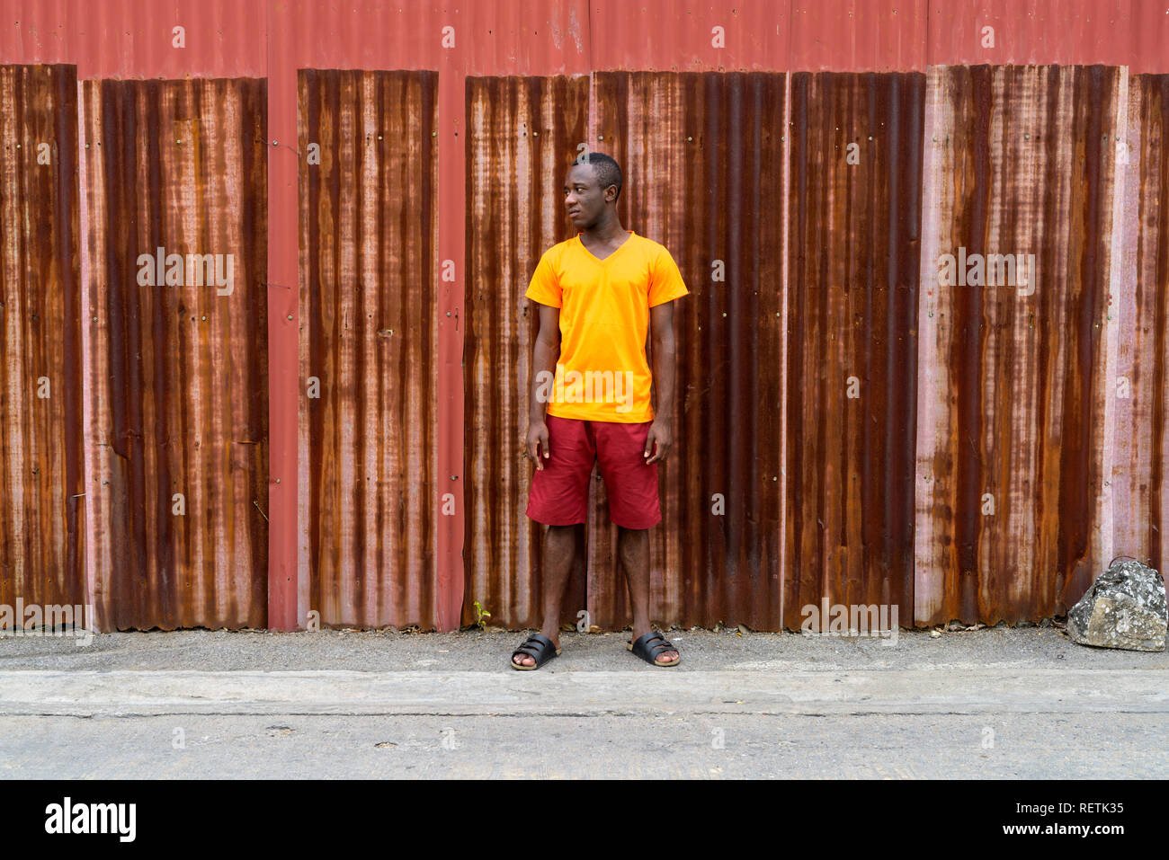 Young black African man standing while thinking and looking at d Stock Photo