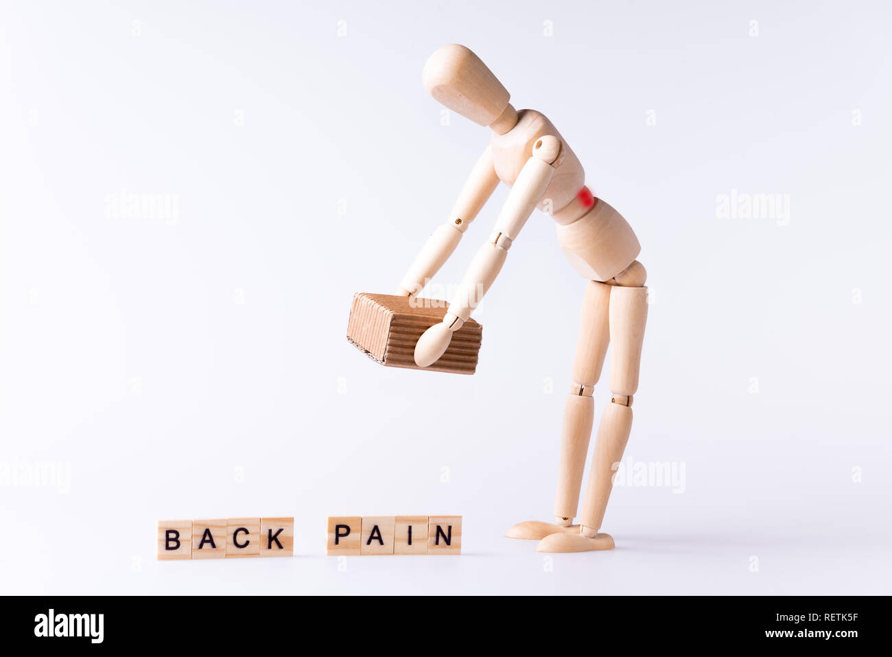 Wood man lifting brown box with red spot and letters back pain Stock Photo