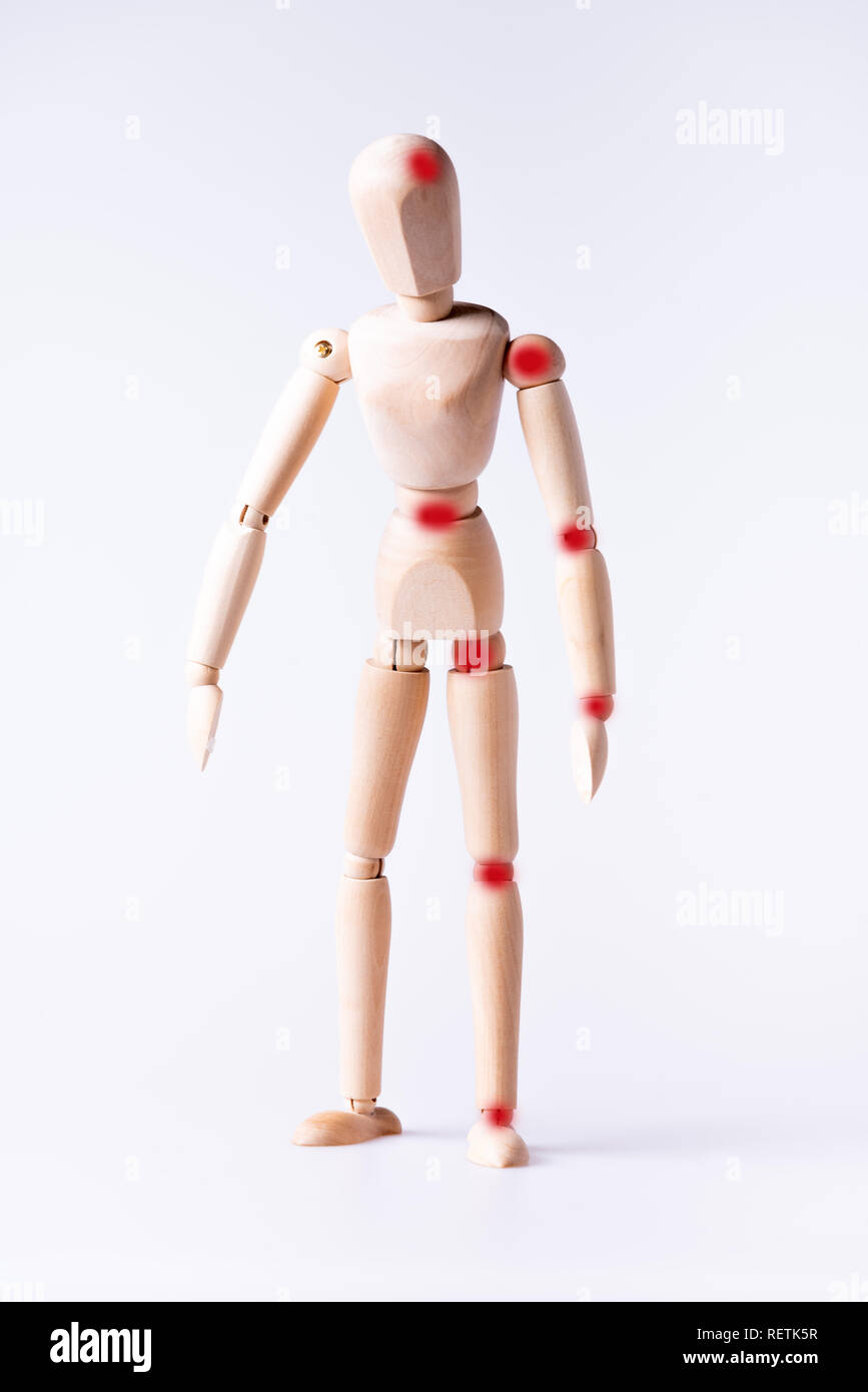 Red spots on body parts, hurts,pain or injury on wood man standing alone Stock Photo