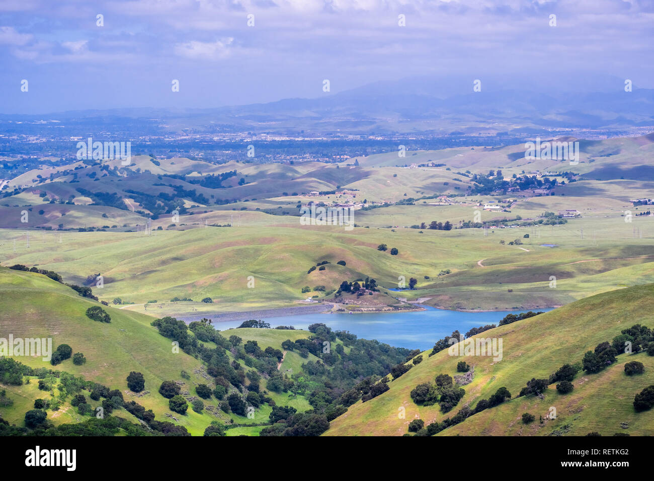 View towards San Antonio reservoir surrounded green hills; Pleasanton and Mt Diablo in the background, Alameda county, San Francisco bay area, Califor Stock Photo