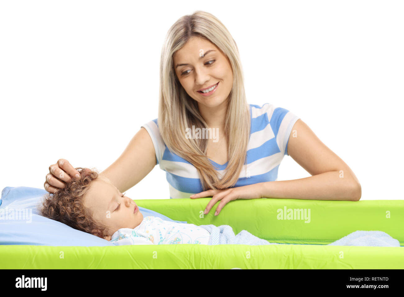 Young mother stroking her baby while sleeping in a cot isolated on white background Stock Photo