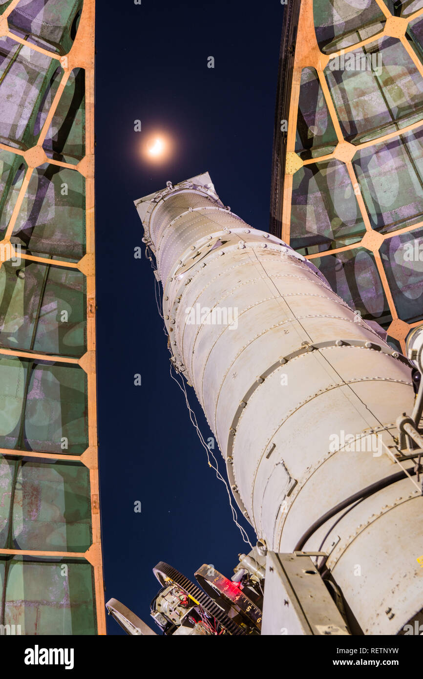 Old telescope looking towards the moon through the opened dome of an observatory Stock Photo