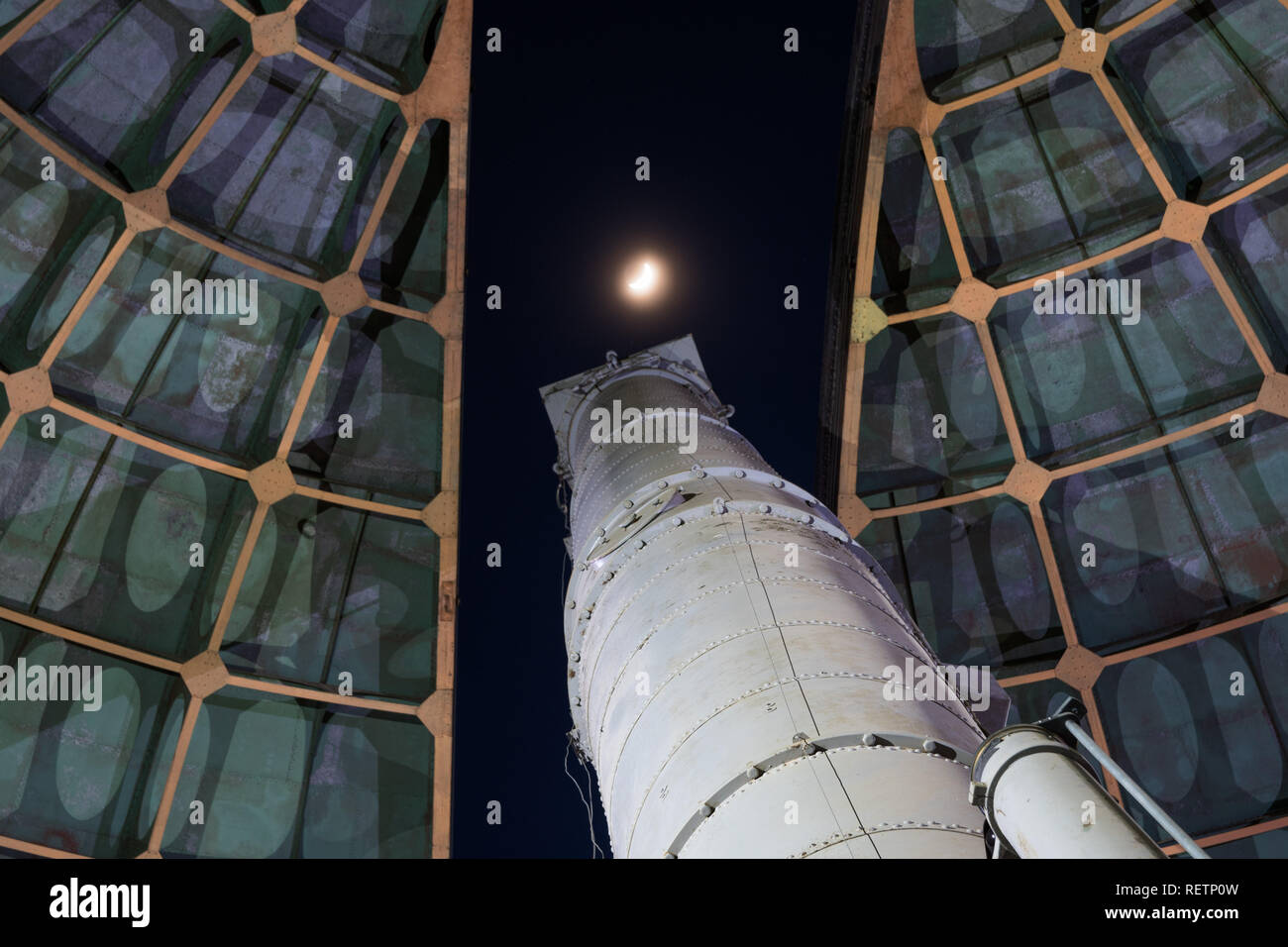 Old telescope looking towards the moon through the opened dome of an observatory Stock Photo