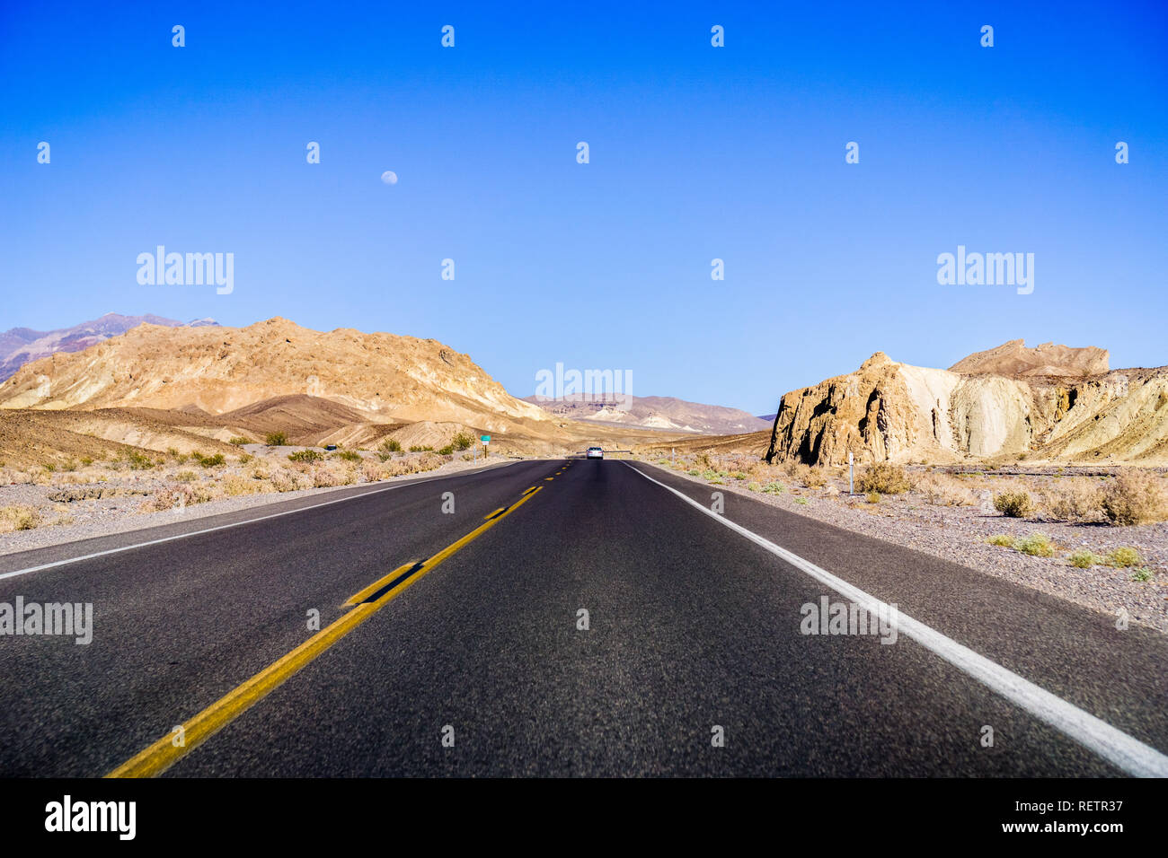 Travelling through Death Valley National Park, moon rising up in the sky; California Stock Photo
