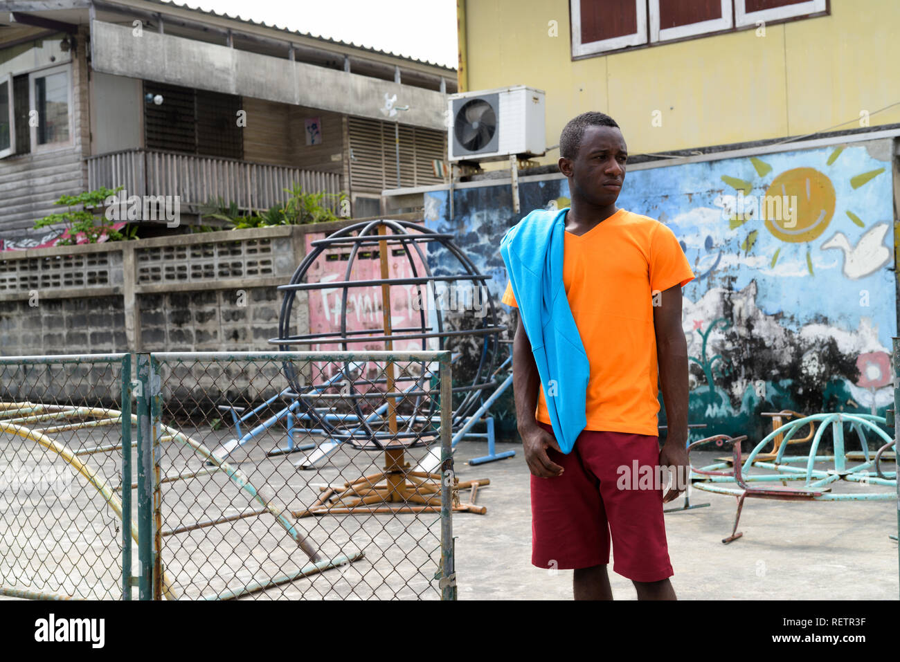 Young black African man thinking with jacket over his shoulder w Stock Photo