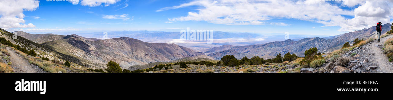 Panoramic view towards Badwater Basin from the trail to Telescope Peak, Death Valley National Park, hiker following a trail on the right, California Stock Photo