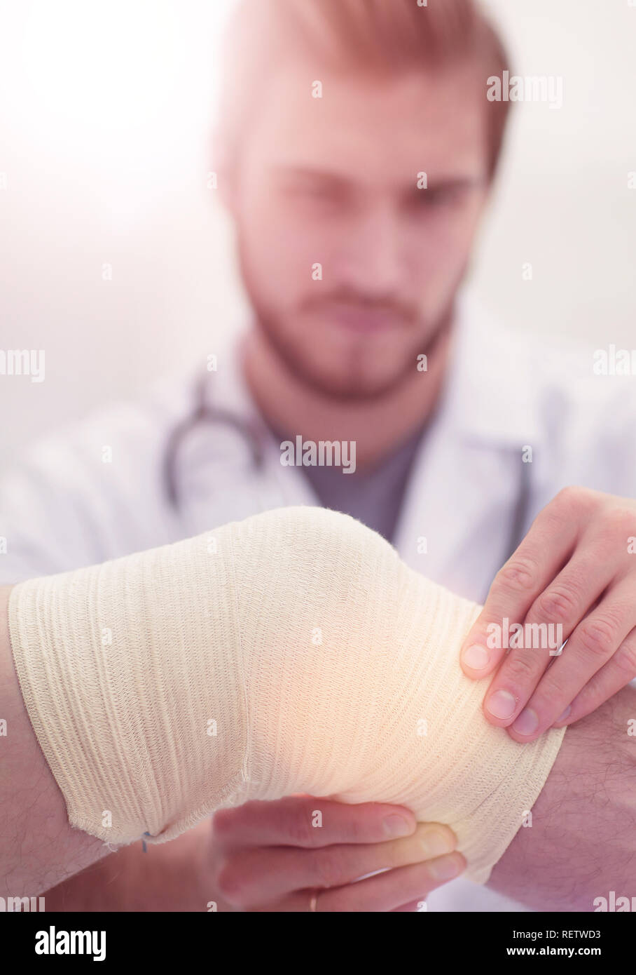 traumatologist examining the bandage on his knee Stock Photo Alamy
