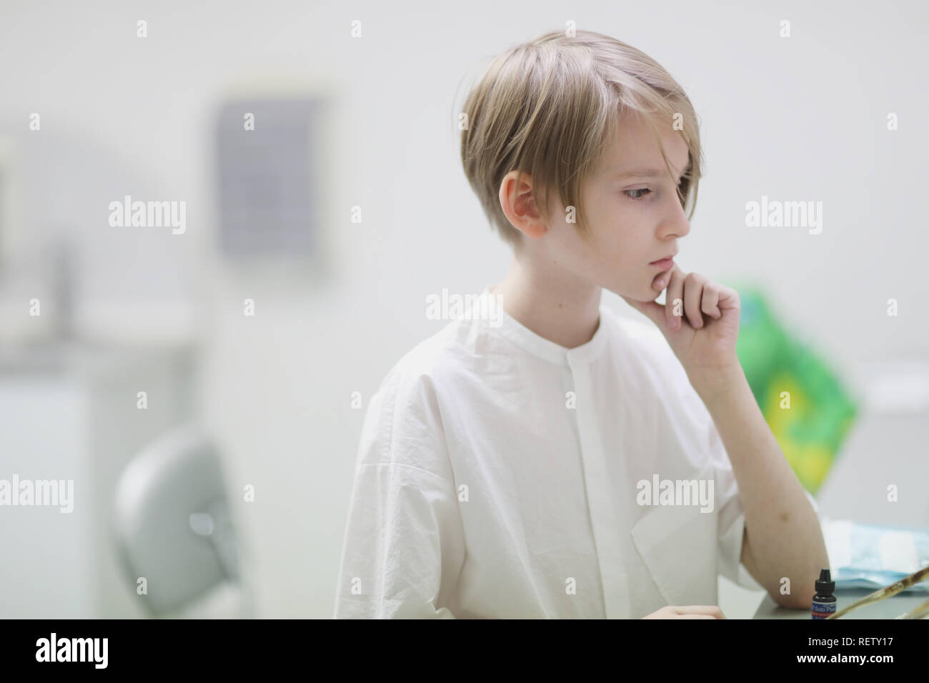 A Boy Of School Age With A Stylish Haircut And In White Clothes