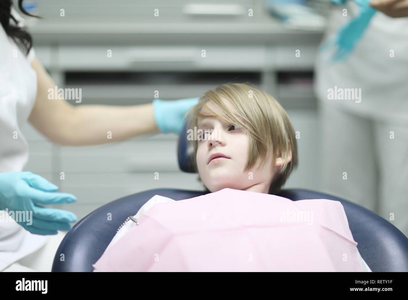 A Boy Of School Age With A Stylish Haircut Is In The Dental Chair
