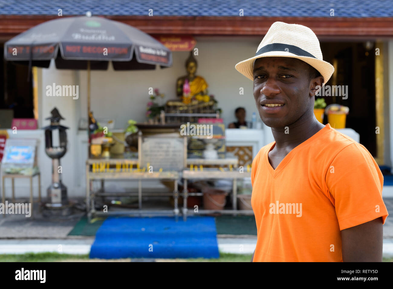 Young black African tourist man smiling at Buddhist temple Stock Photo