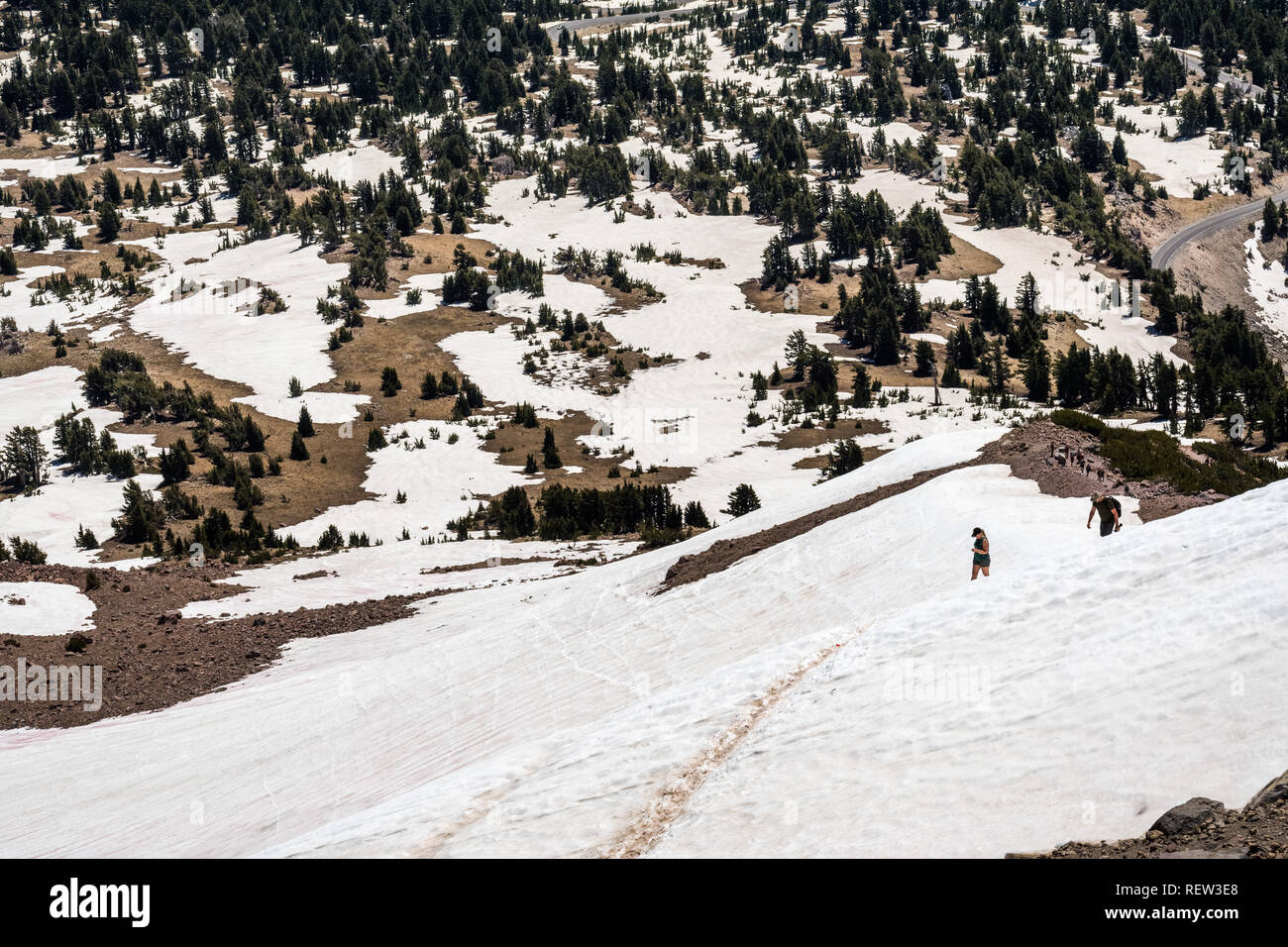 High altitude hiking trail to Lassen Peak still covered in snow on a sunny summer day; Lassen Volcanic National Park, Shasta County, California Stock Photo