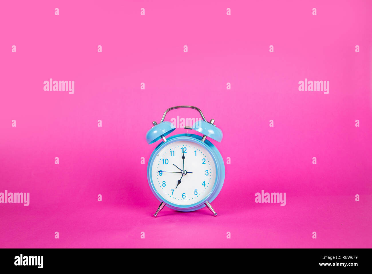 Beautiful retro blue pastel alarm clock on a vibrant pink background ...