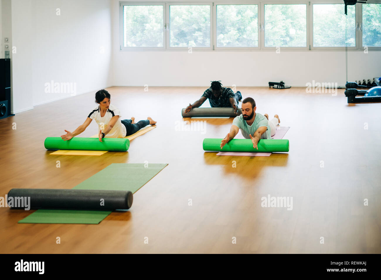 People doing exercises with foam rollers in the gym Stock Photo - Alamy