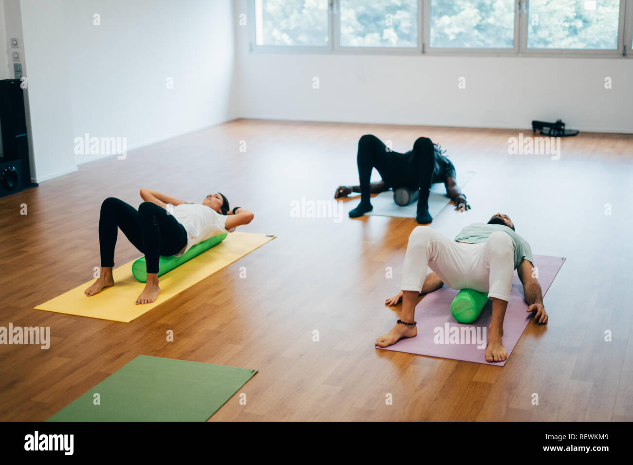 People doing exercises with foam rollers in the gym Stock Photo - Alamy