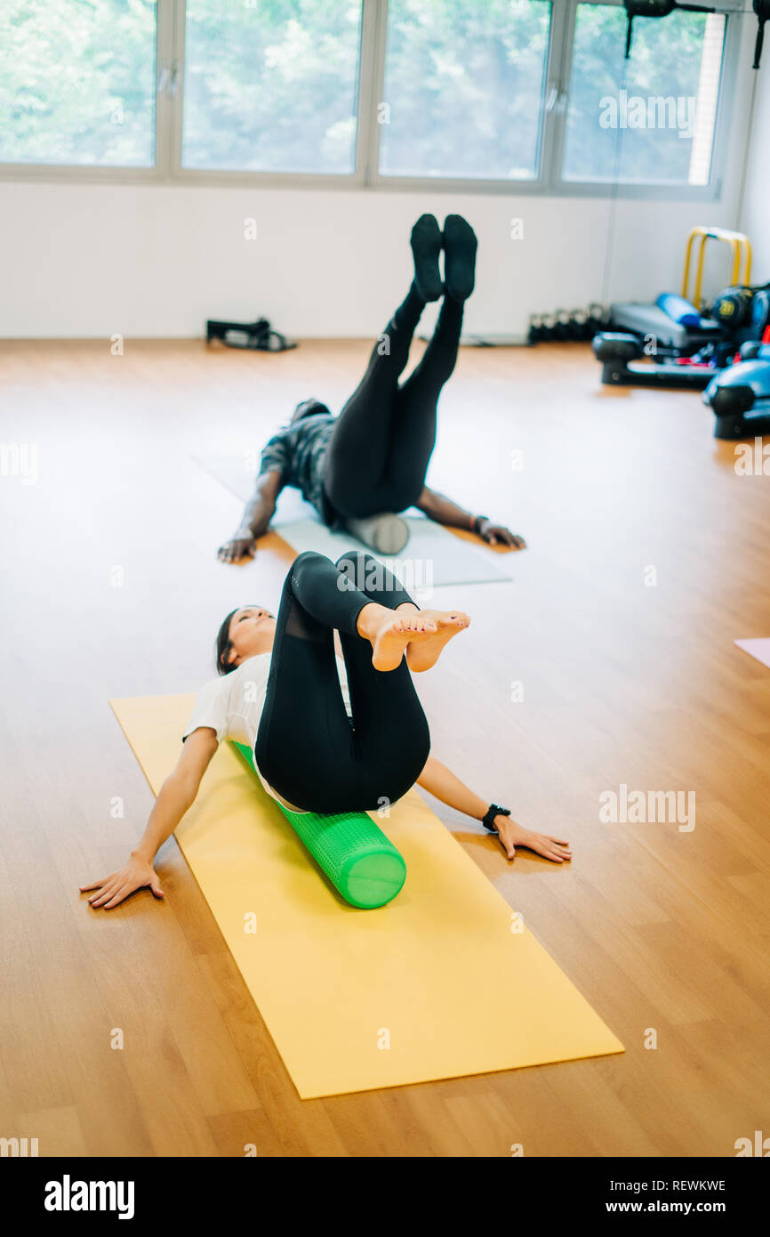 People doing exercises with foam rollers in the gym Stock Photo Alamy
