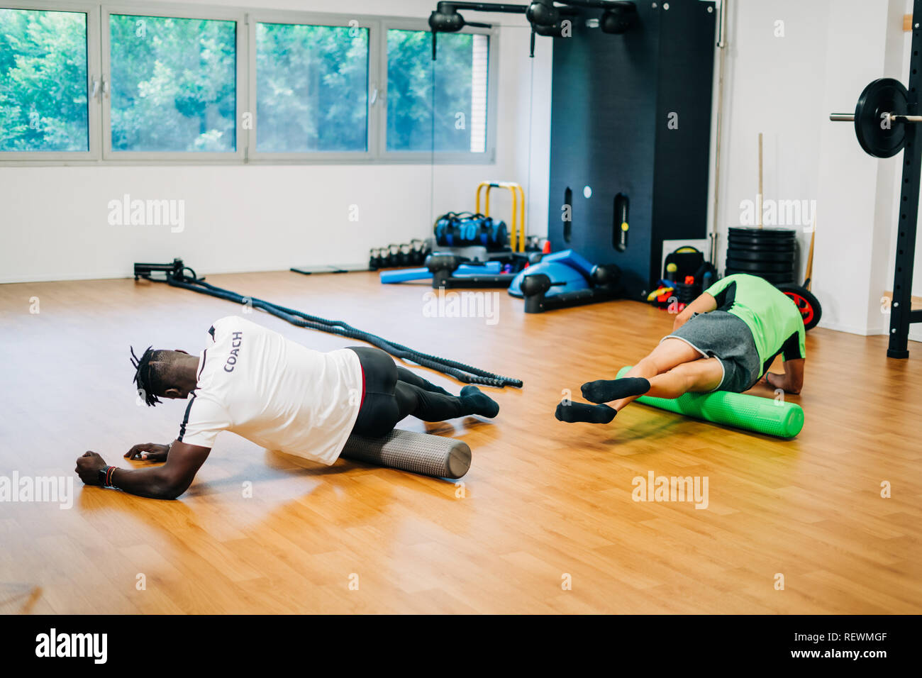 People doing exercises with foam rollers in the gym Stock Photo - Alamy