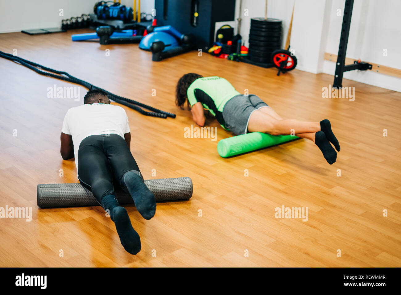 People doing exercises with foam rollers in the gym Stock Photo - Alamy