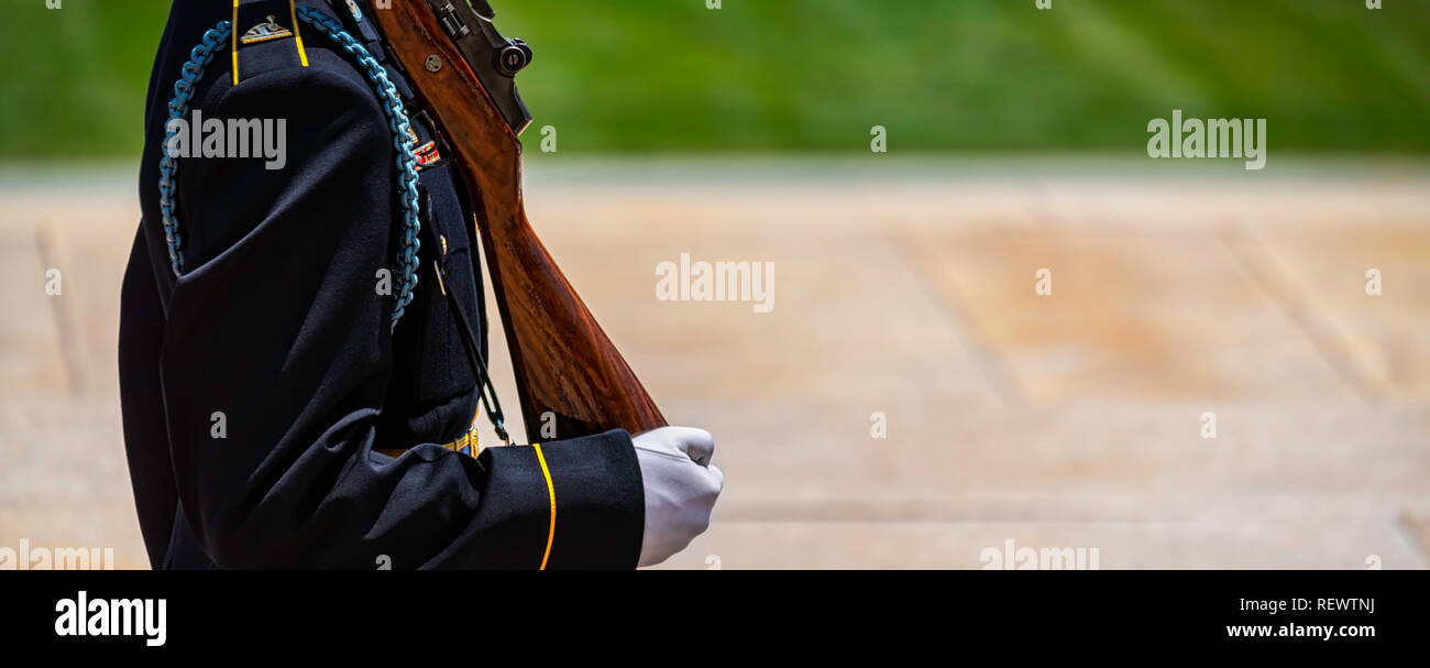 An Army soldier, in white gloves, carrying his weapon on guard duty. Stock Photo