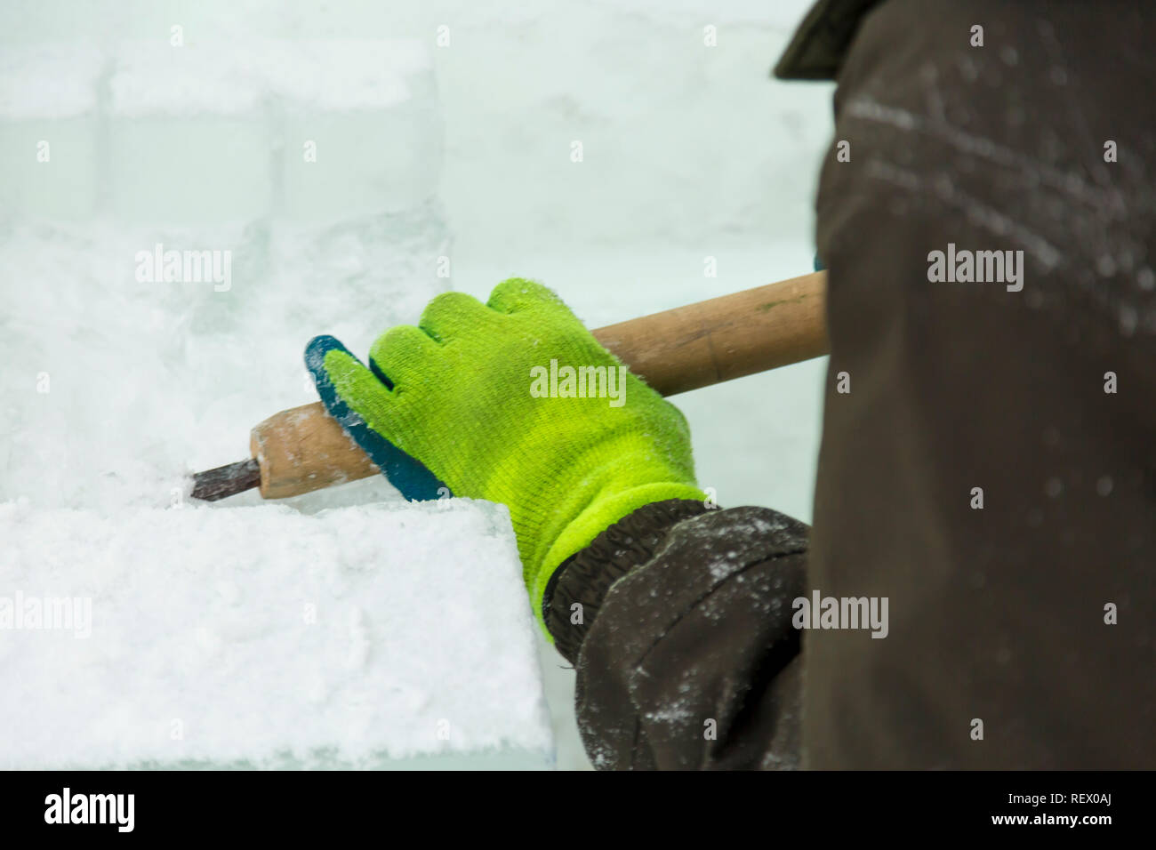 The sculptor cuts an ice figure out of an ice block with a chisel Stock ...