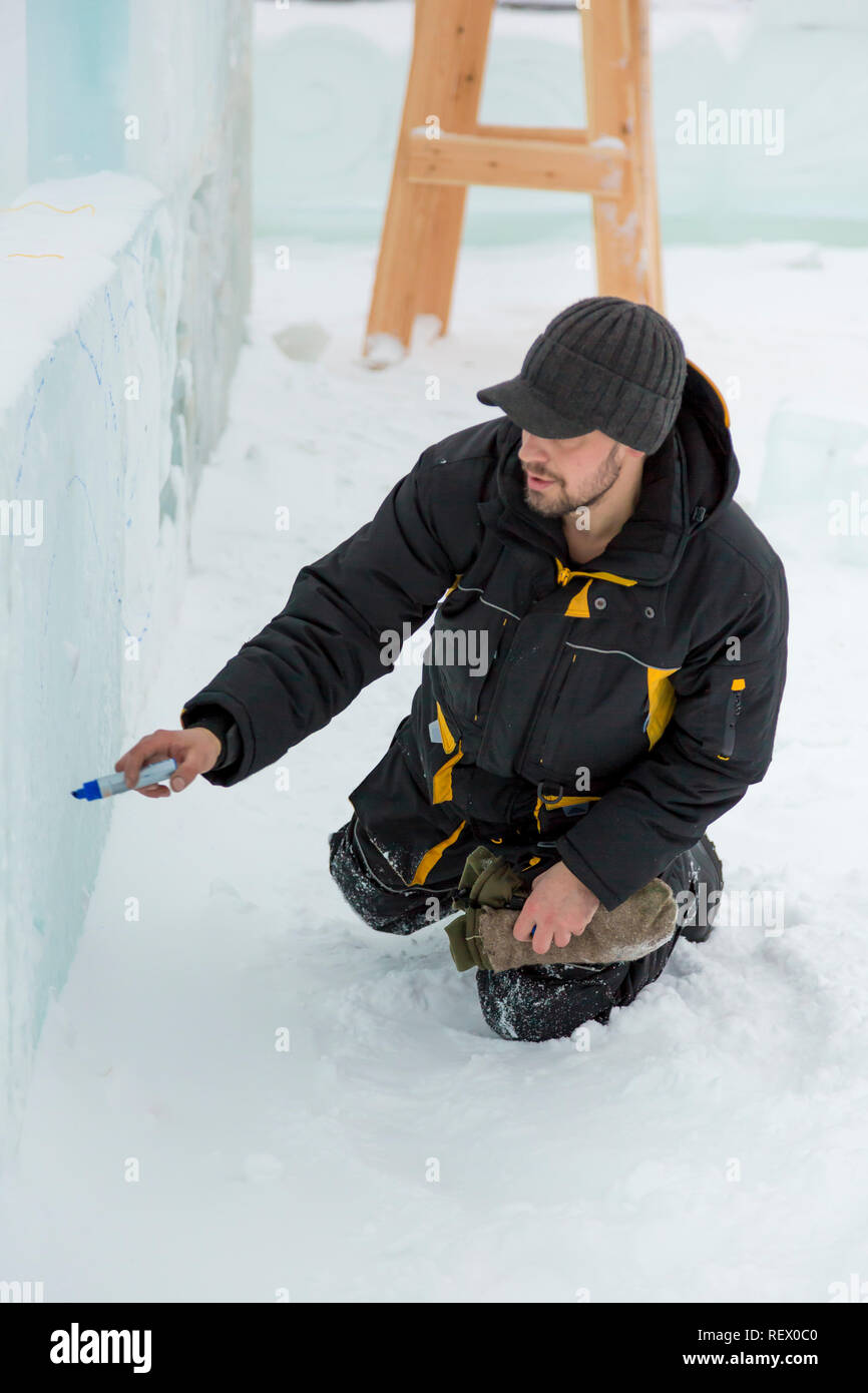 The artist draws the contours of the future ice figure on the ice Stock