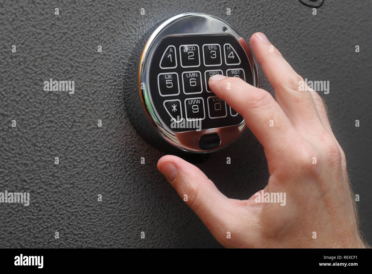 Hands entering combination to open digital lock on safe Stock Photo Alamy