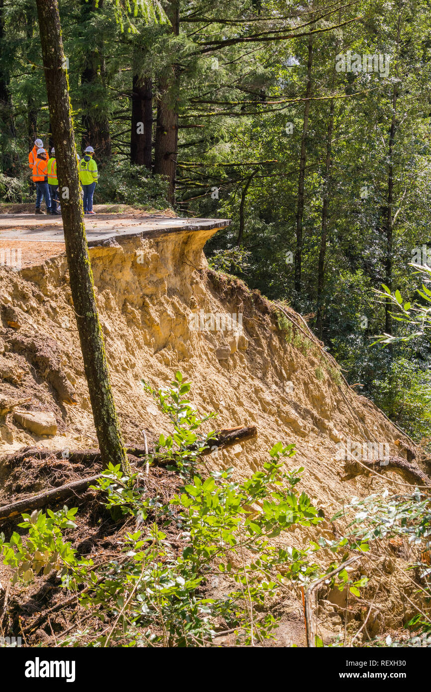 March 27, 2017 Los Gatos/CA/USA - People standing on the edge are discussing solutions regarding a collapsed paved road due to a landslide as result o Stock Photo