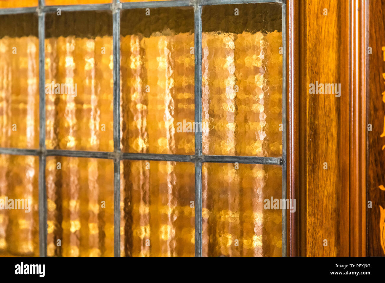 Books in antique wooden bookcase with frosted glass doors Stock Photo