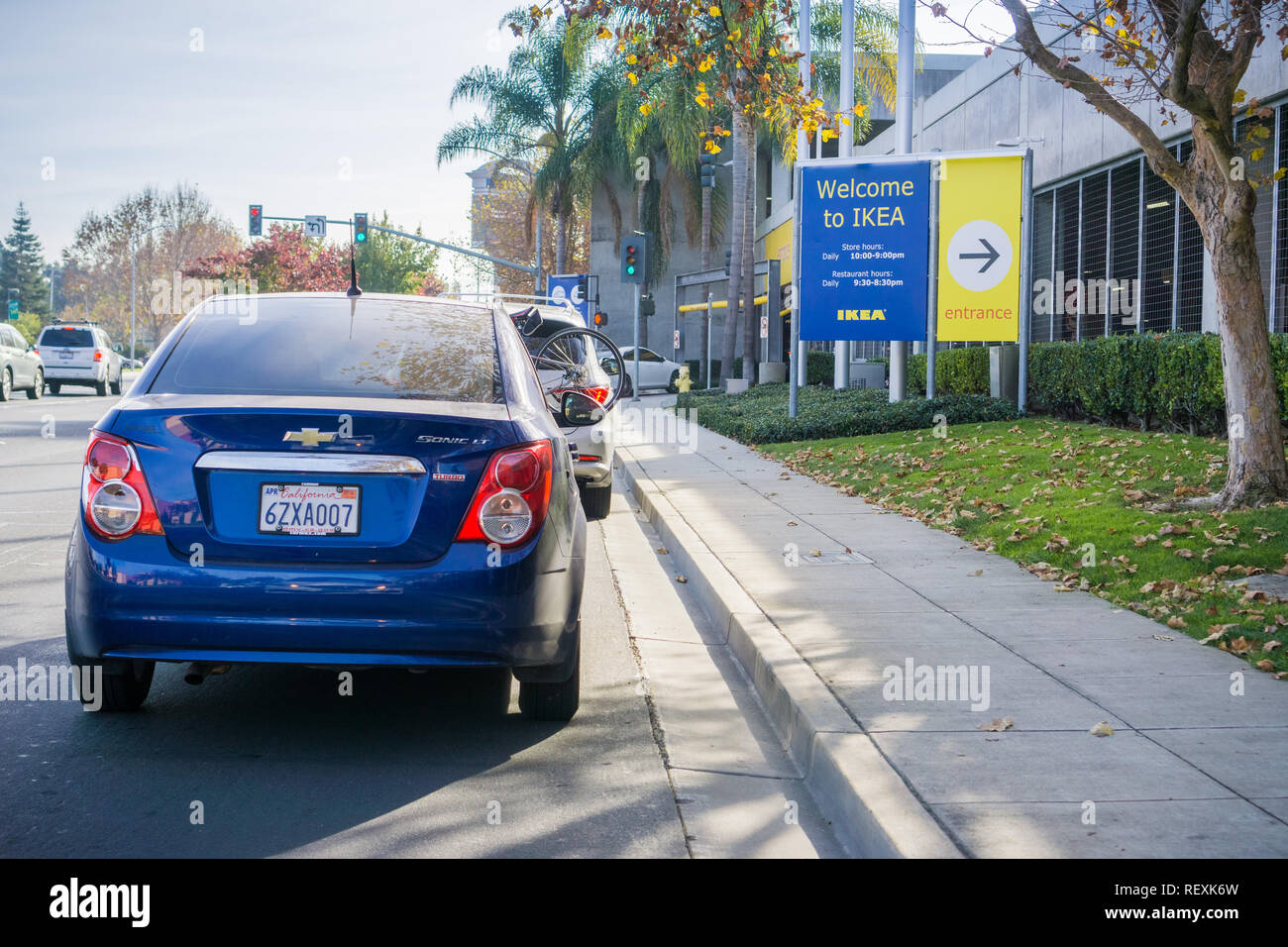 December 9, 2017 East Palo Alto / CA / USA - Cars waiting in line to enter the IKEA parking lot; Welcome to IKEA sign and store hours displayed at the Stock Photo