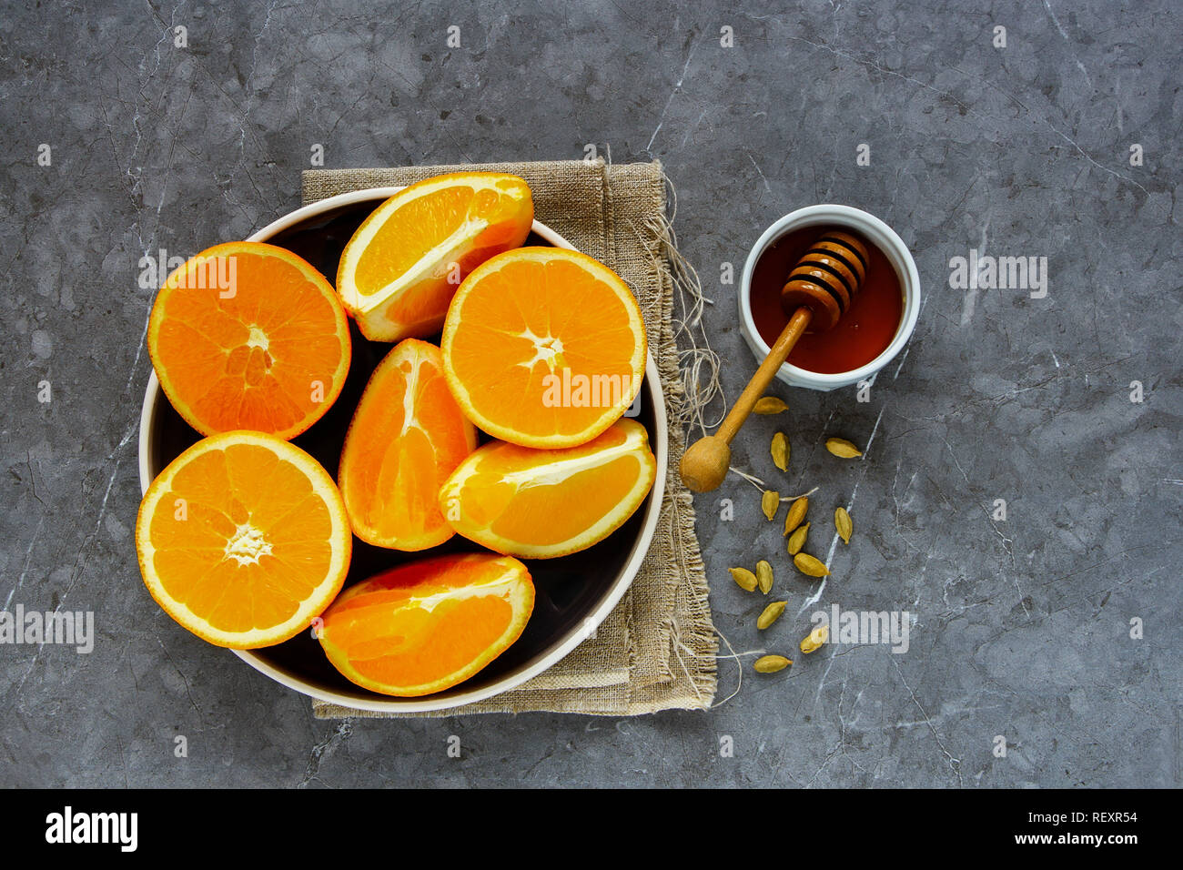 Making natural hot drink. Flat-lay of fresh oranges, honey and spices Stock Photo