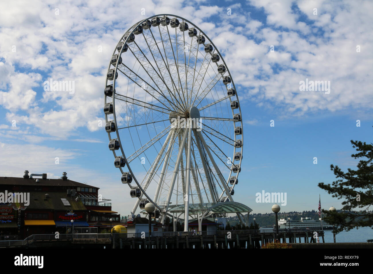 Seattle Big Wheel jumbo ferris wheel on the pier on a partly cloudy day Stock Photo