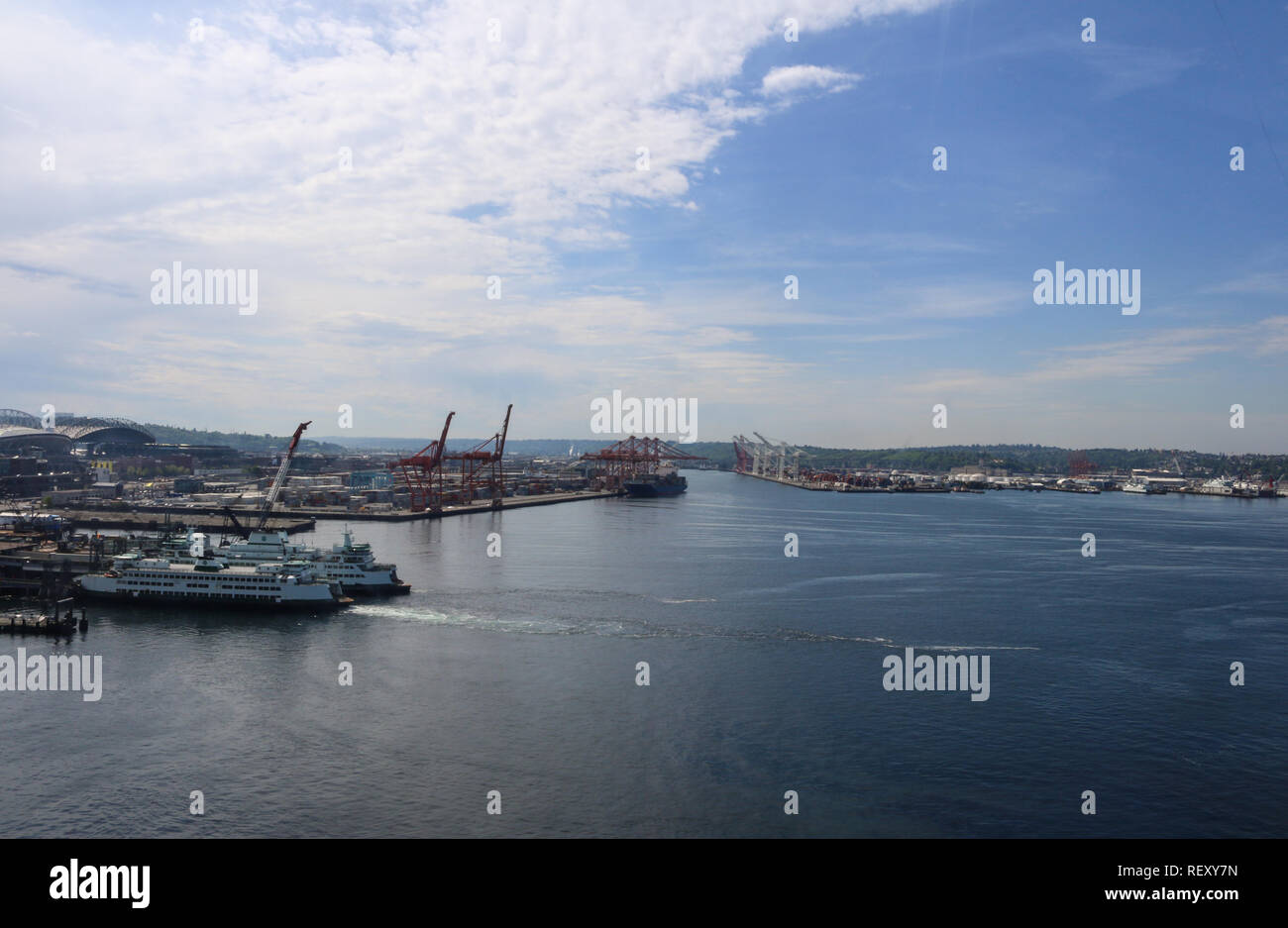 Seattle Puget Sound harbor marine landscape aerial view on a sunny partly cloudy day with two cruise ships docked and rows of ports in the background Stock Photo