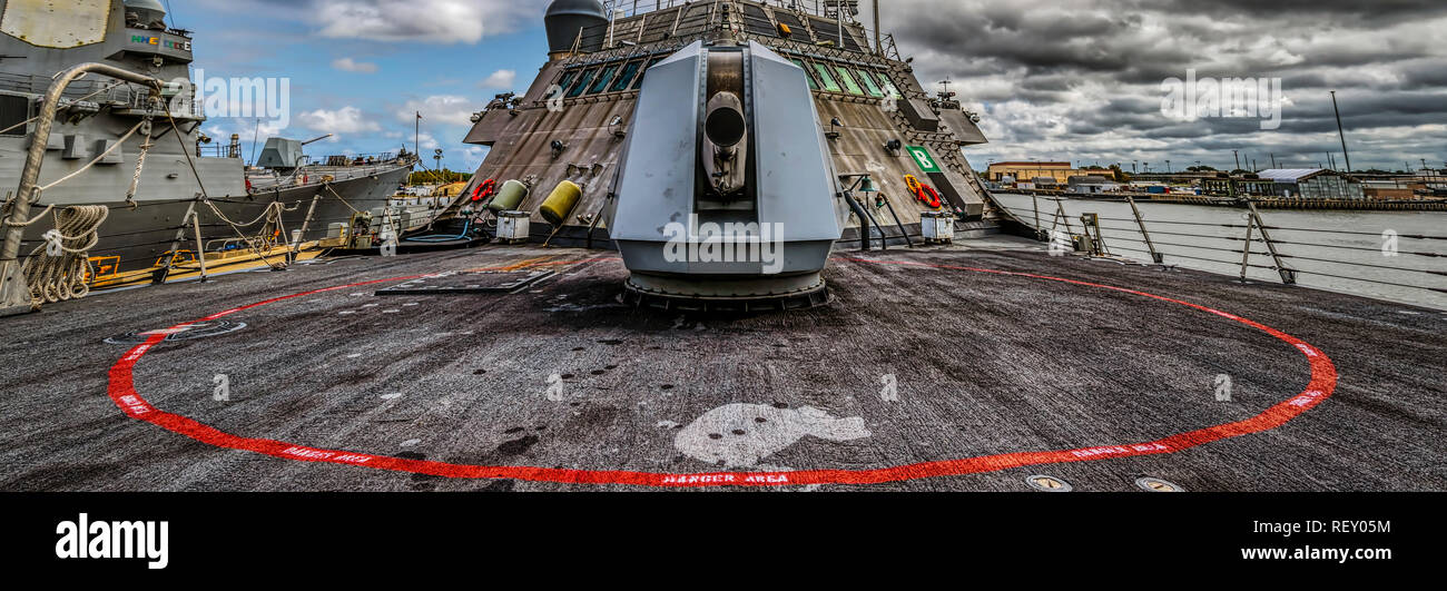 The main 57mm gun, and its red circle â€œdanger zoneâ€ of an American warship on a cloudy October day. Stock Photo