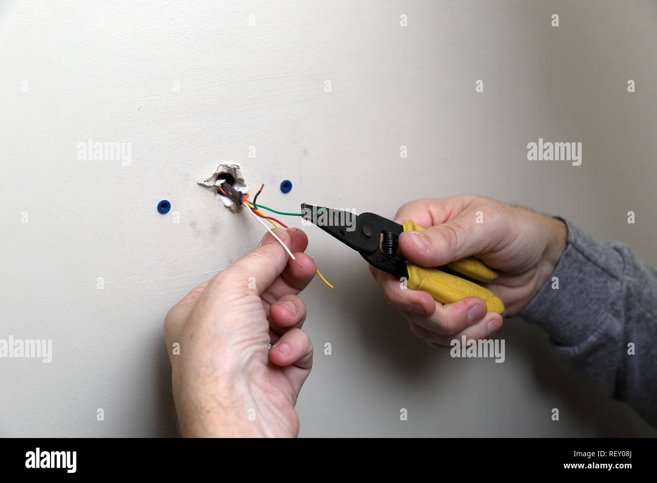 Control wire for thermostat used with a HVAC unit, coming out of wall during installation Stock Photo