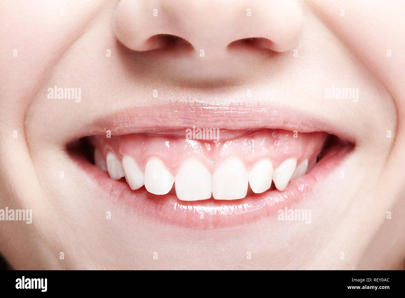 Closeup shot of human female face. Woman with pink lips and healthy dentes. Girl is smiling Stock Photo