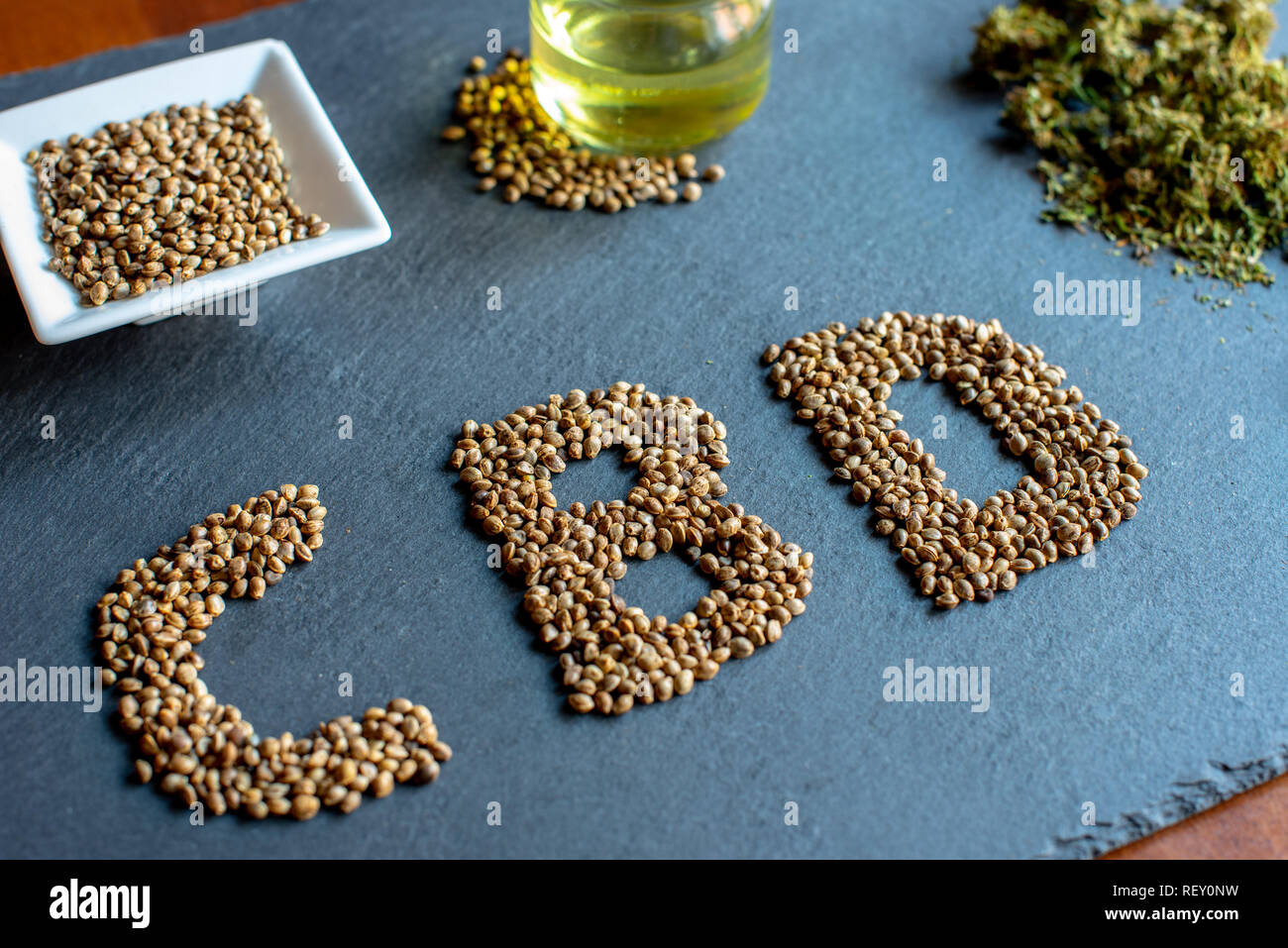 initials of the active ingredient cbd on a slate with medical marijuana sprouts, hemp seeds, essential oil Stock Photo