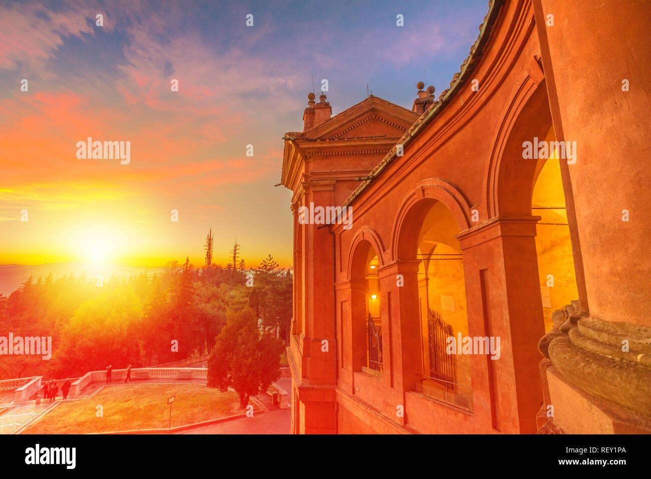 Scenic landscape of courtyard with the light of the sunset and of the side view of the Sanctuary of Madonna di San Luca. The church of the Blessed Virgin of St. Luke is a pilgrimage destination. Stock Photo