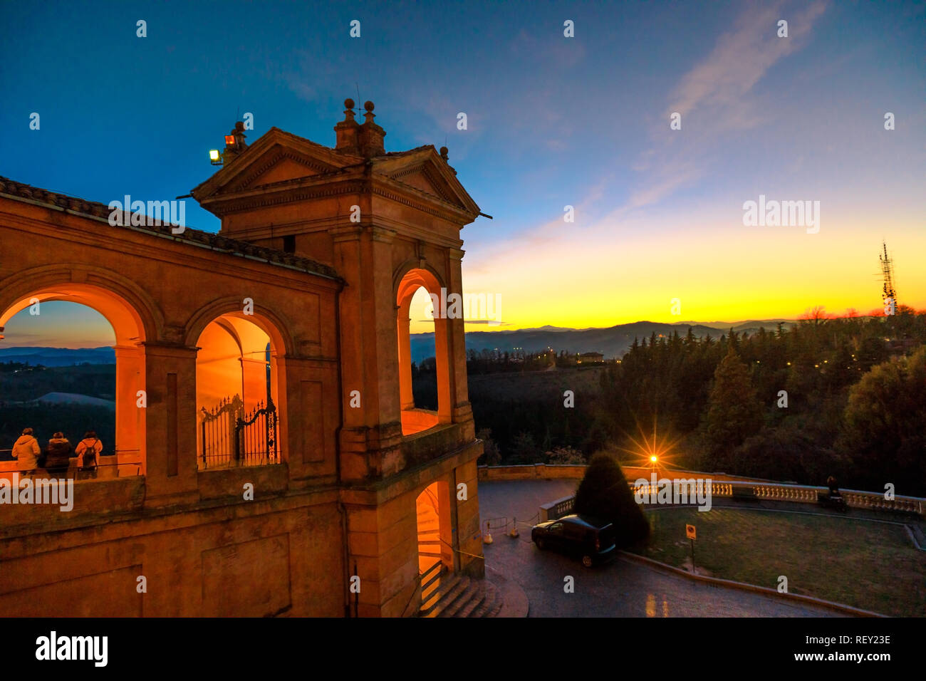 Side view of Sanctuary of Blessed Virgin of San Luca and Colle della Guardia above city of Bologna at illuminated at twilight. Famous pilgrinage place in Emilia-Romagna, Italy. Stock Photo