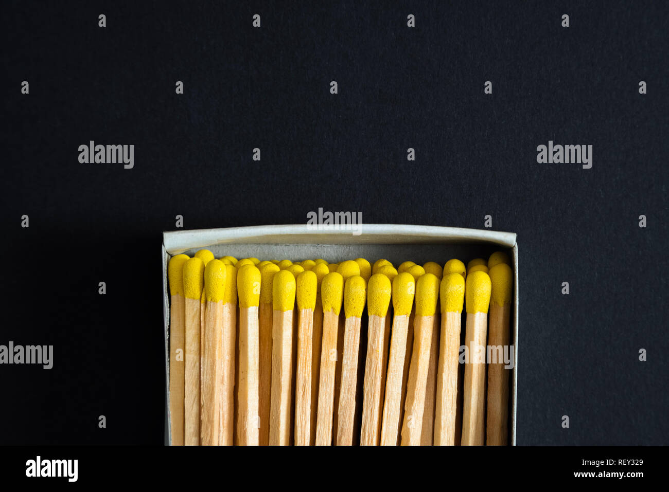 Matches with yellow heads in a box, dark background. Macro photography. Matches in open match-box Stock Photo