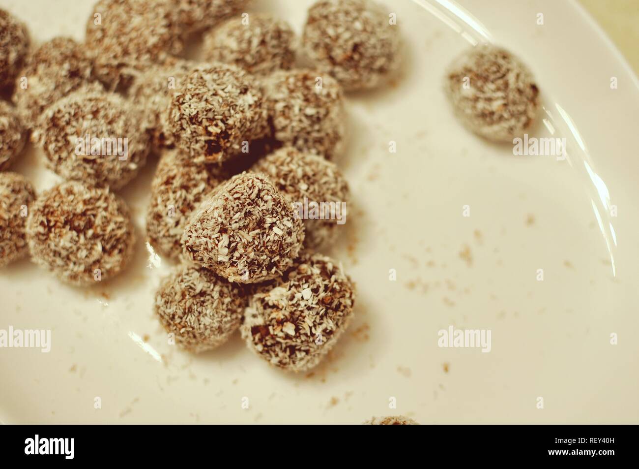Close up of a white plate with homemade cocoa and coconut cookies bullets Stock Photo