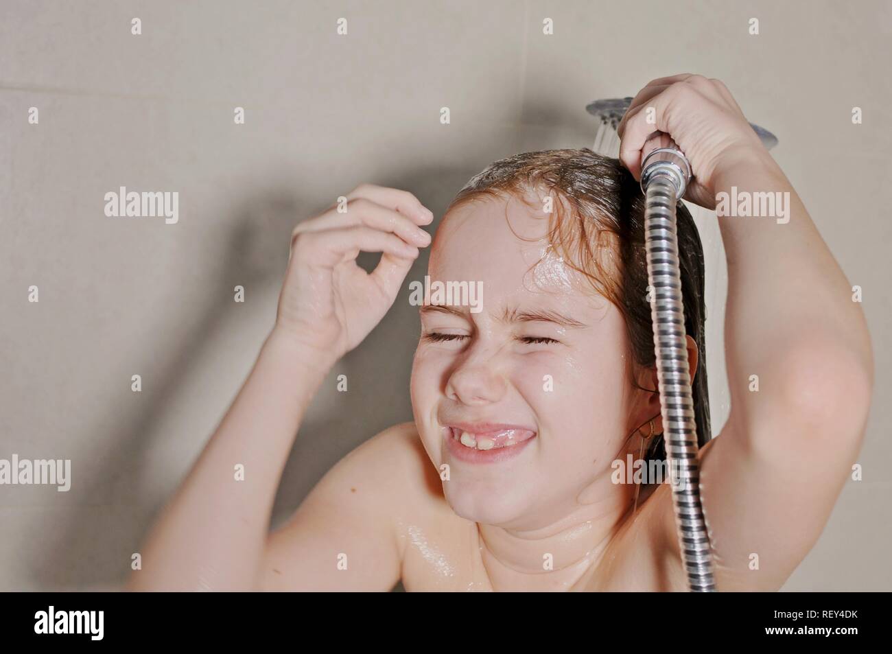 White Caucasian girl (child, kid) taking shower and laughing in the bath Stock Photo 232936191
