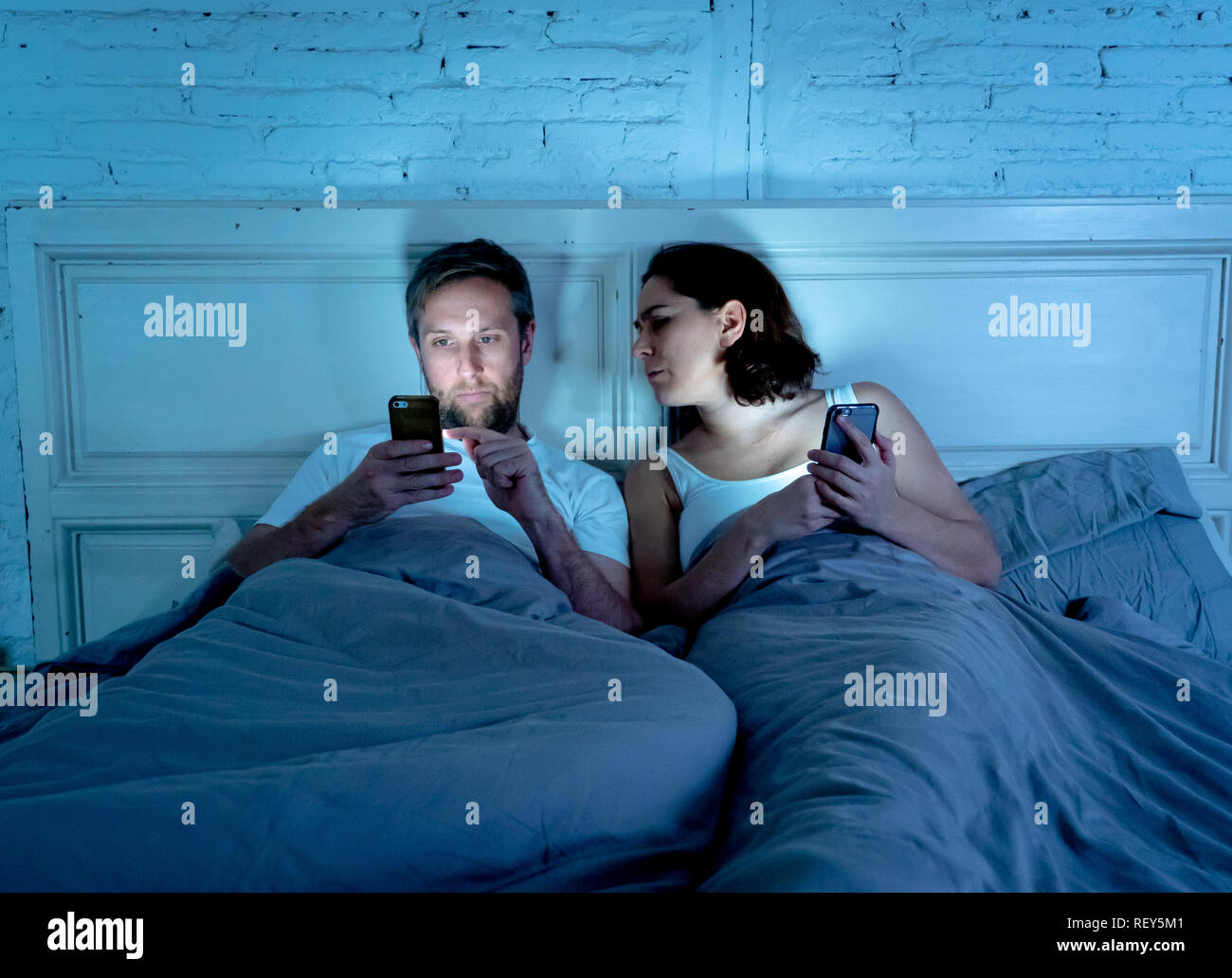 Lifestyle of mobile addicted man husband and angry frustrated wife woman feeling ignored and upset in Internet, Social media Games and Technology addi Stock Photo