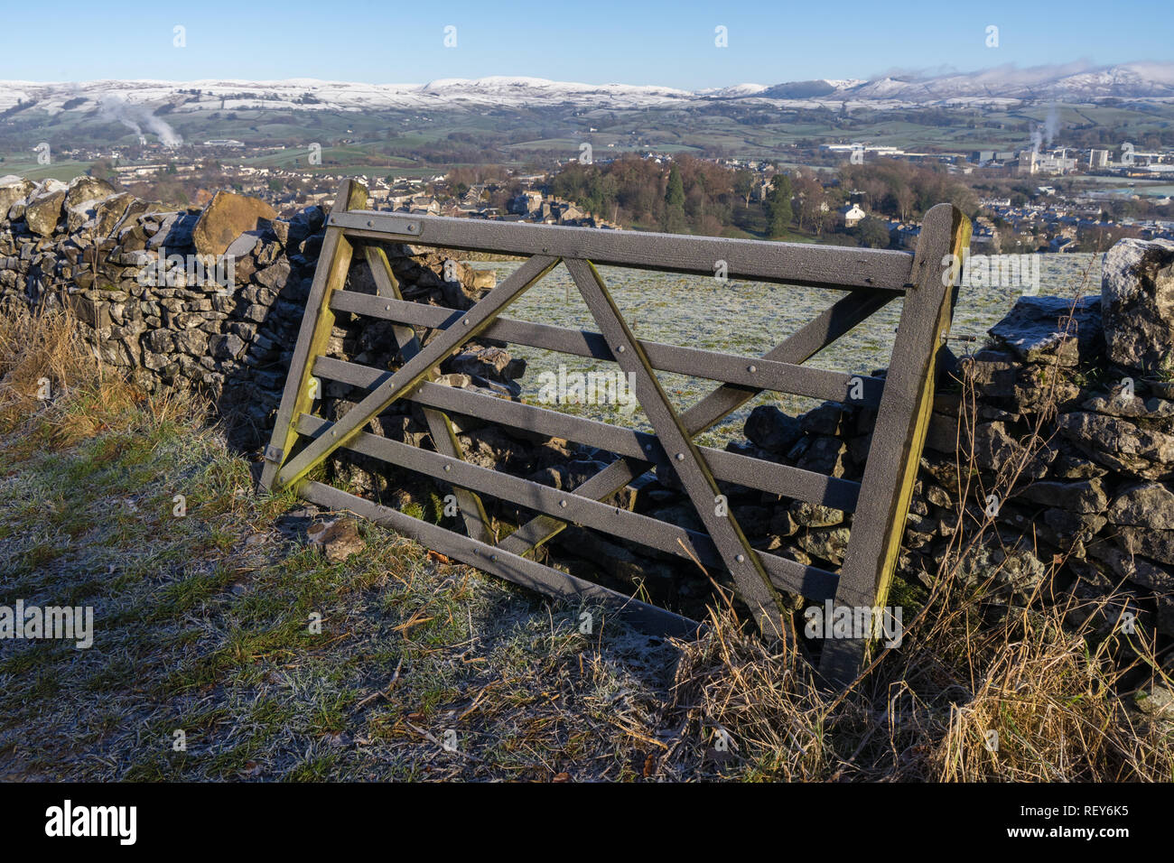 A 5 bar gate leaning against a damaged dry stone wall on a clear bright frosty morning Stock Photo