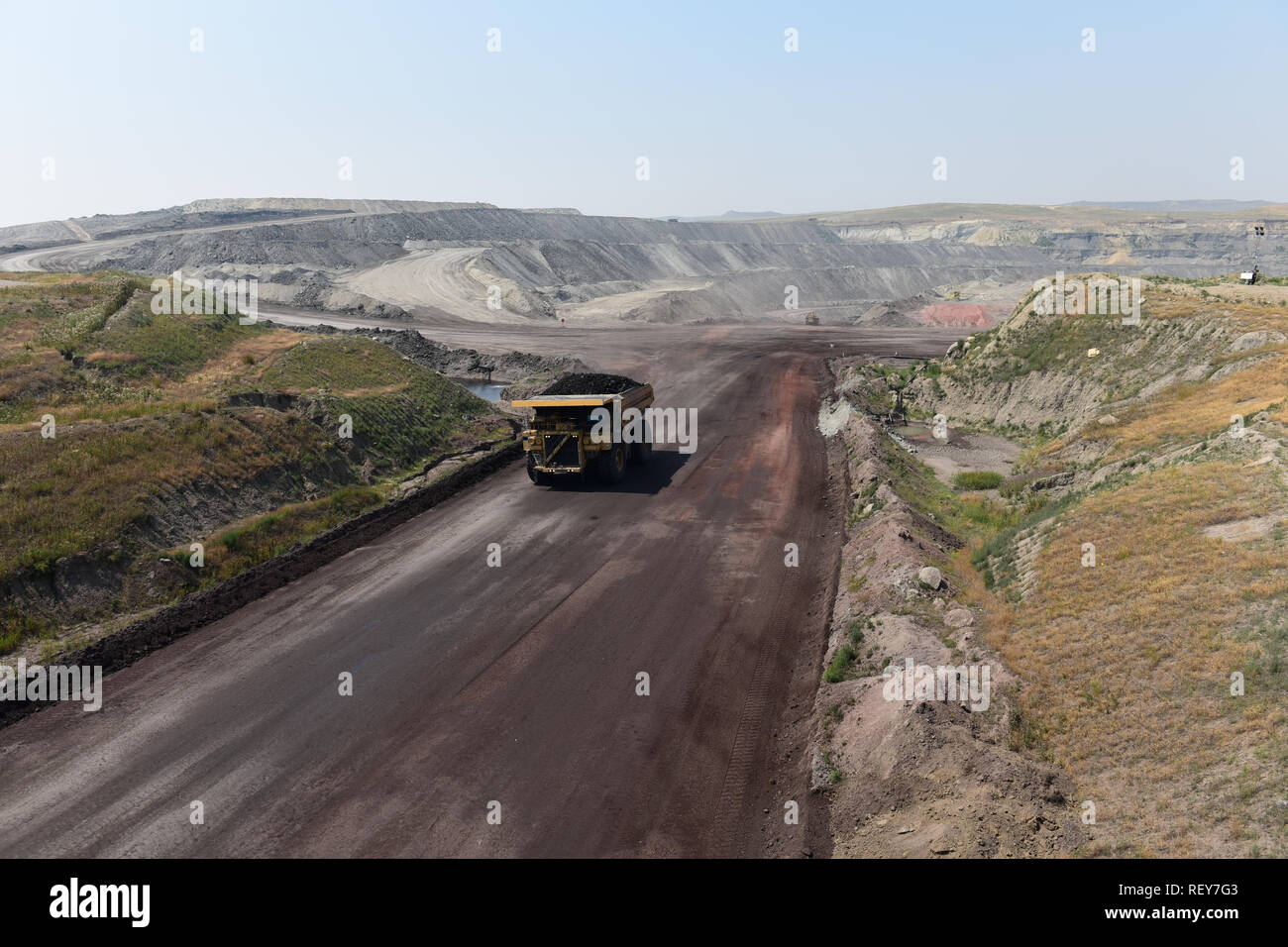 A large coal mining truck hauls coal inside of a vast open pit coal mine in the Powder River Basin of Wyoming, USA. Stock Photo